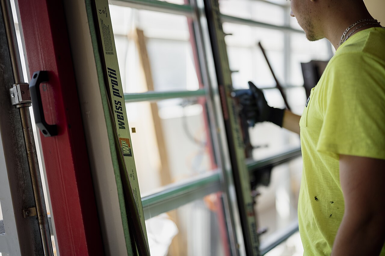 Installer fitting a new window frame for Family First Remodeling