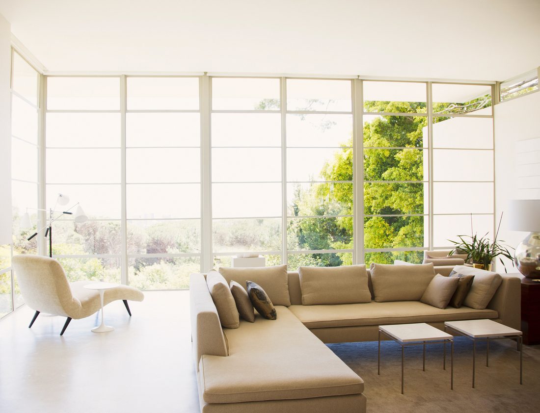 Sunlit living room with floor-to-ceiling windows by Family First Remodeling