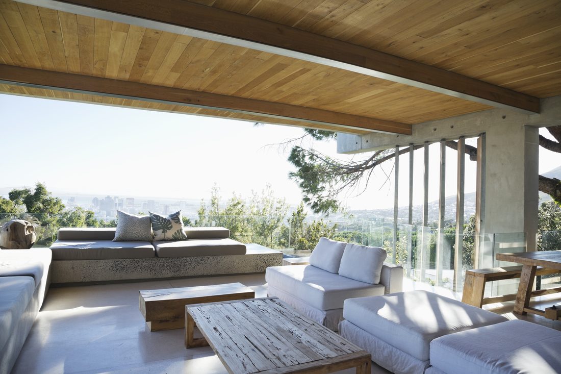 Glass wall opening a living space to the patio and trees